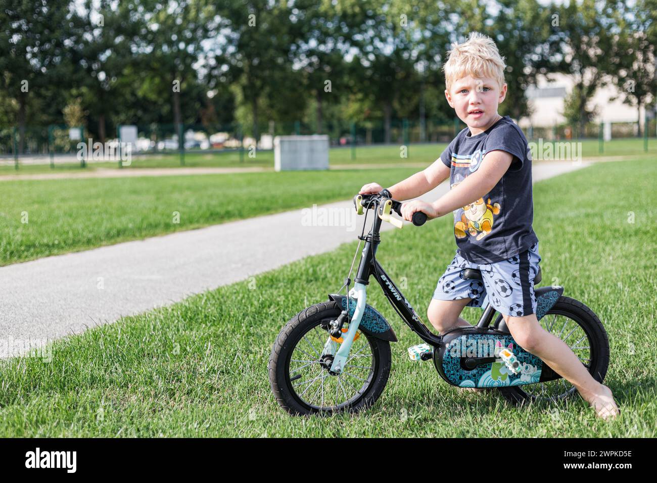 Un ragazzo che va in bicicletta in estate con il casco Foto Stock