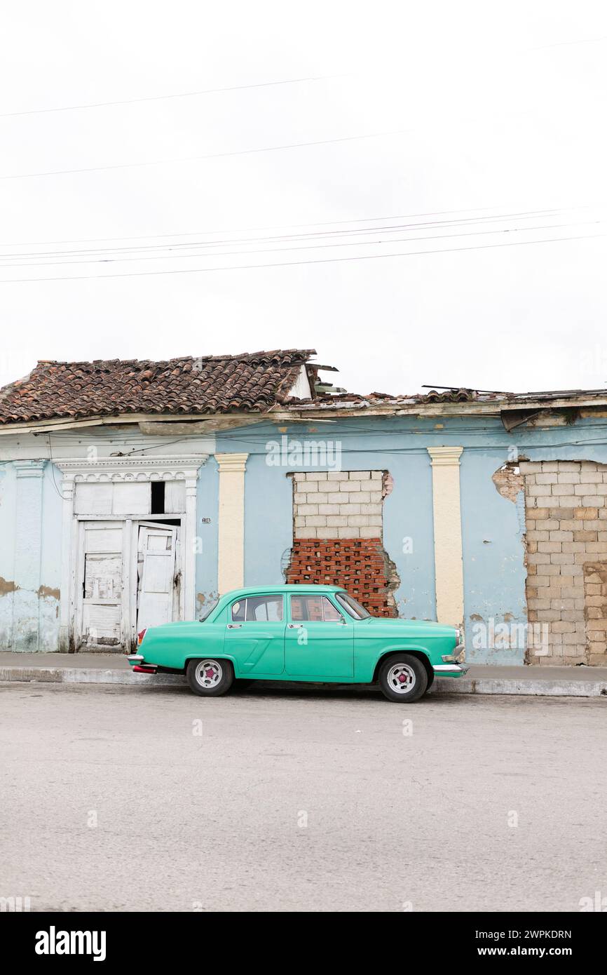 Auto cubana vicino a un edificio maledetto a Santa Clara Foto Stock