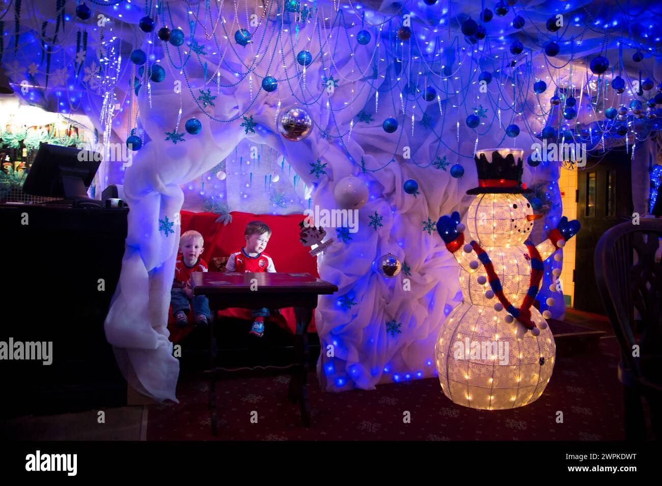 28/11/14 Jacob (2) e Reuben (3) si trovano nell'angolo del pub che è stato trasformato nella grotta di Babbo Natale. Il pub Hanging Gate a Chapel en le Frith, in th Foto Stock