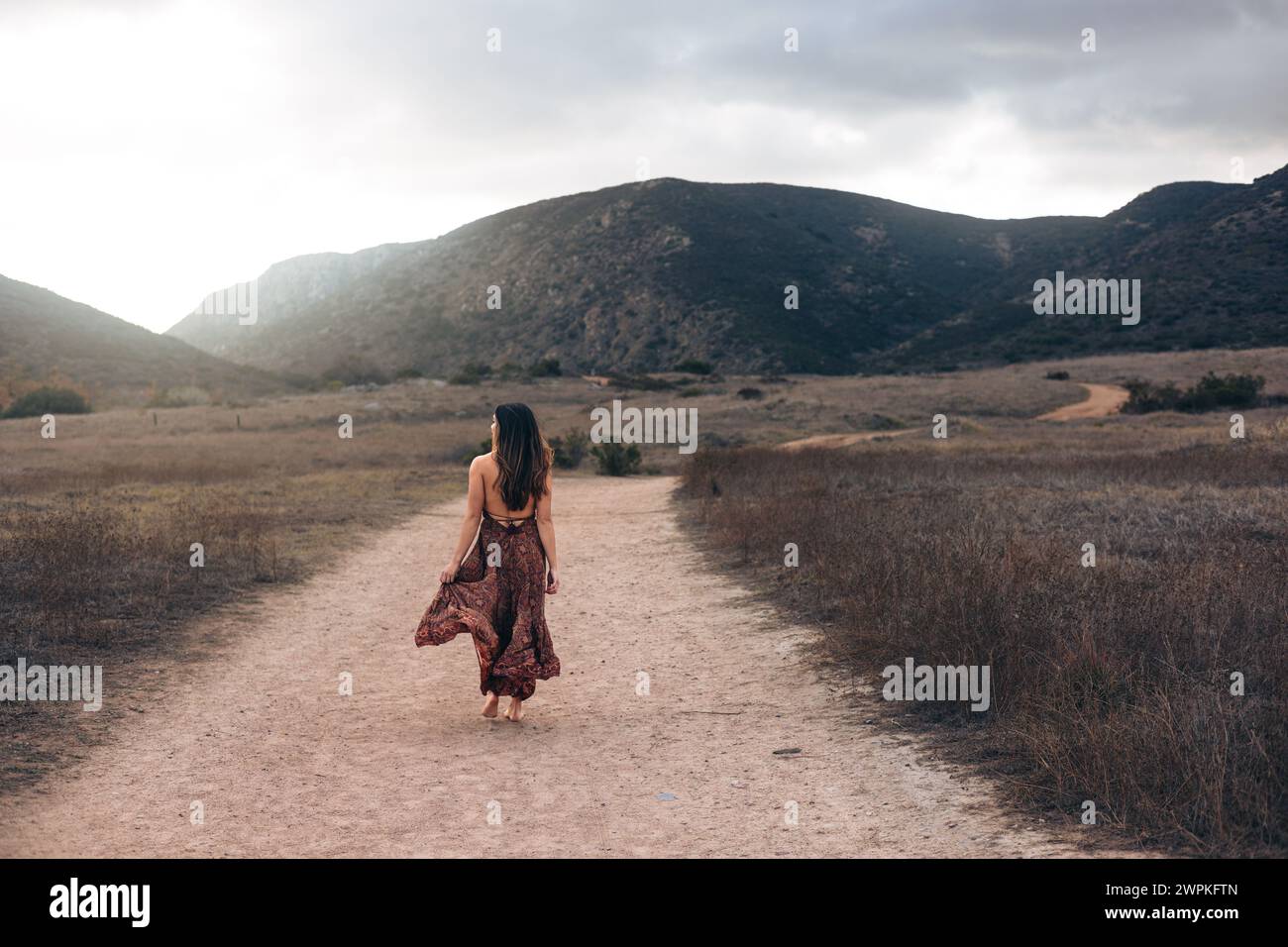 Donna in abito che cammina lungo il sentiero escursionistico a San Diego Foto Stock