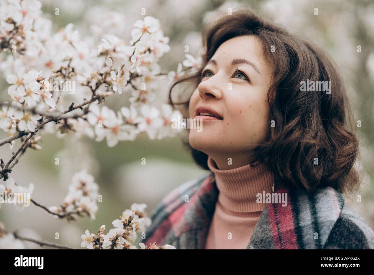 Giovane donna in un giardino di mandorle in fiore a Praga Foto Stock