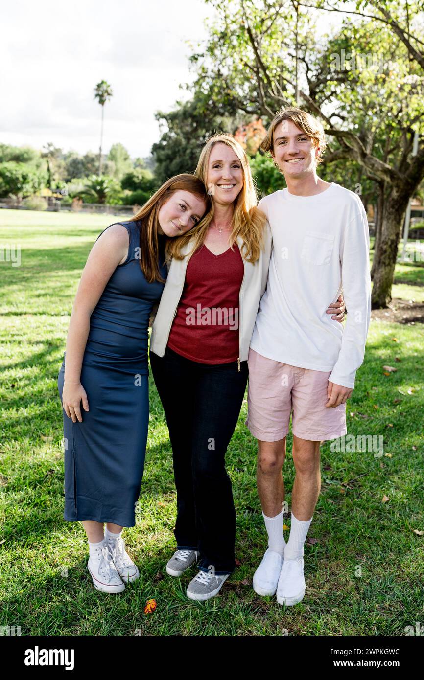Mamma che posa con gli adolescenti al Sunny Day a San Diego Foto Stock