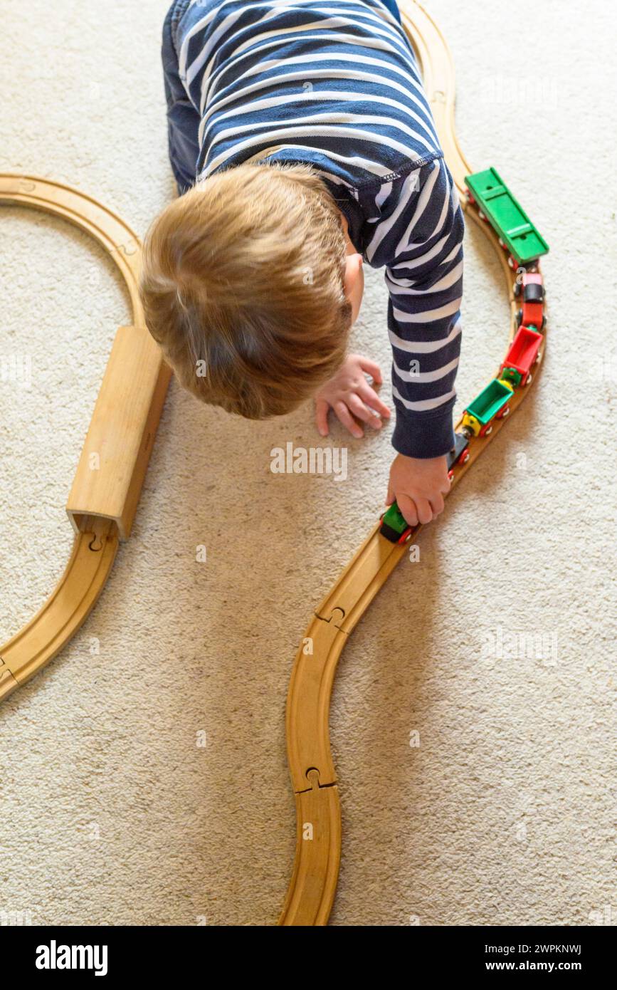 Bambino che gioca con il set di treni di legno Brio. Giocattolo retrò. Foto Stock