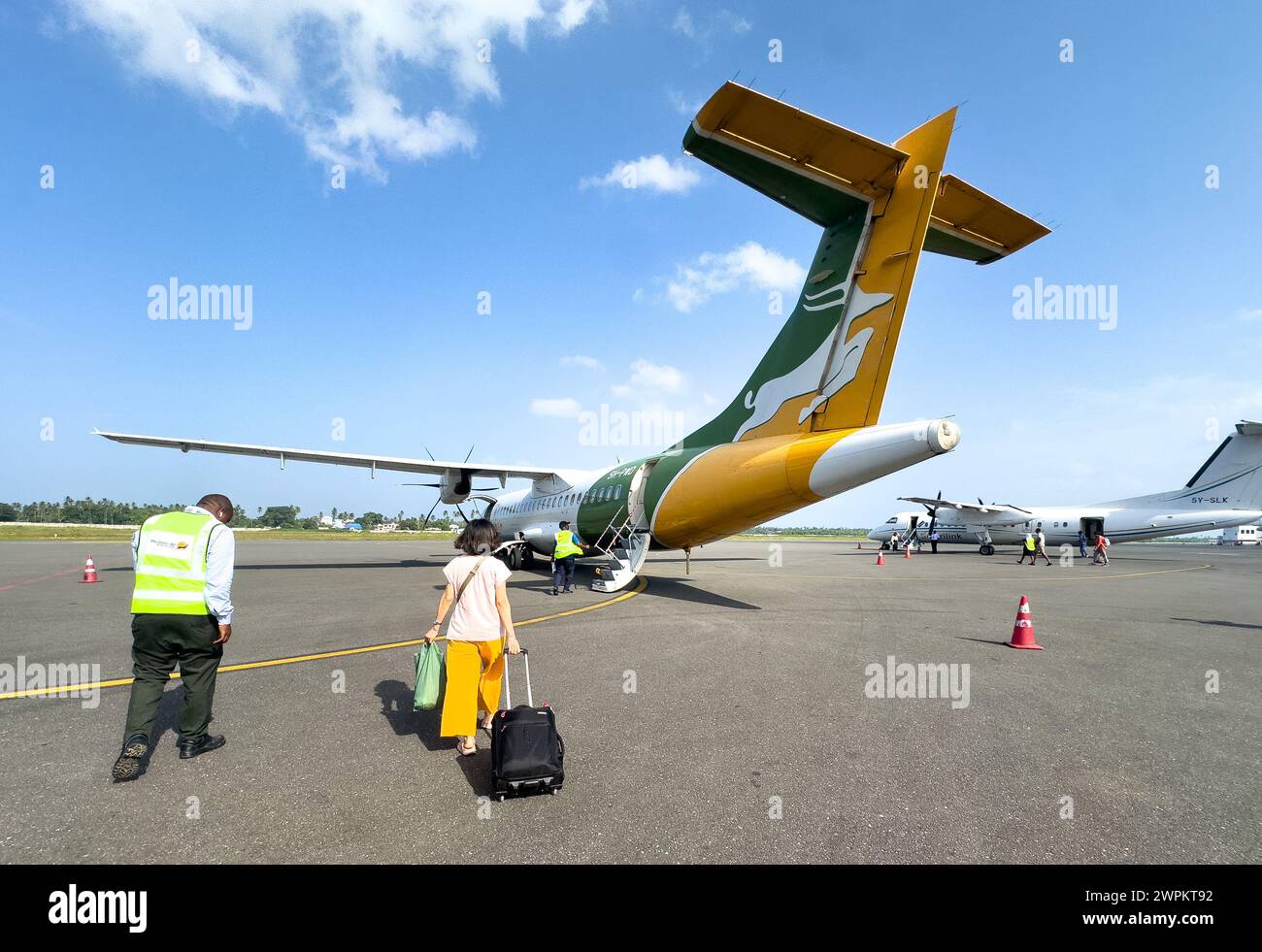 I passeggeri salgono a bordo di un aereo per un volo nazionale all'aeroporto di Zanzibar, Zanzibar, Tanzania Foto Stock