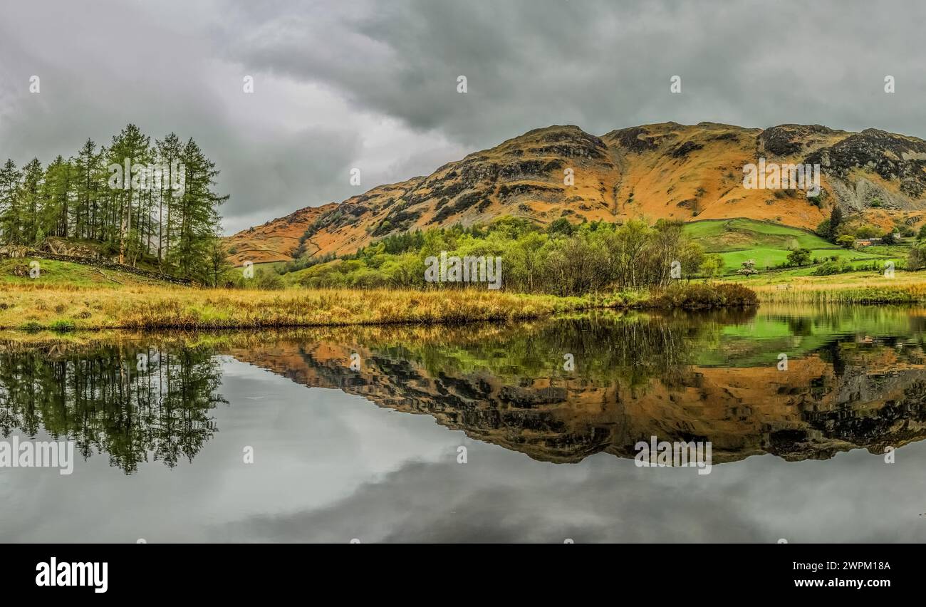 Lingmoor ha fatto cadere i riflessi nel fiume Brathay dalla Little Langdale Valley nel Lake District National Park, UNESCO, Cumbria Foto Stock