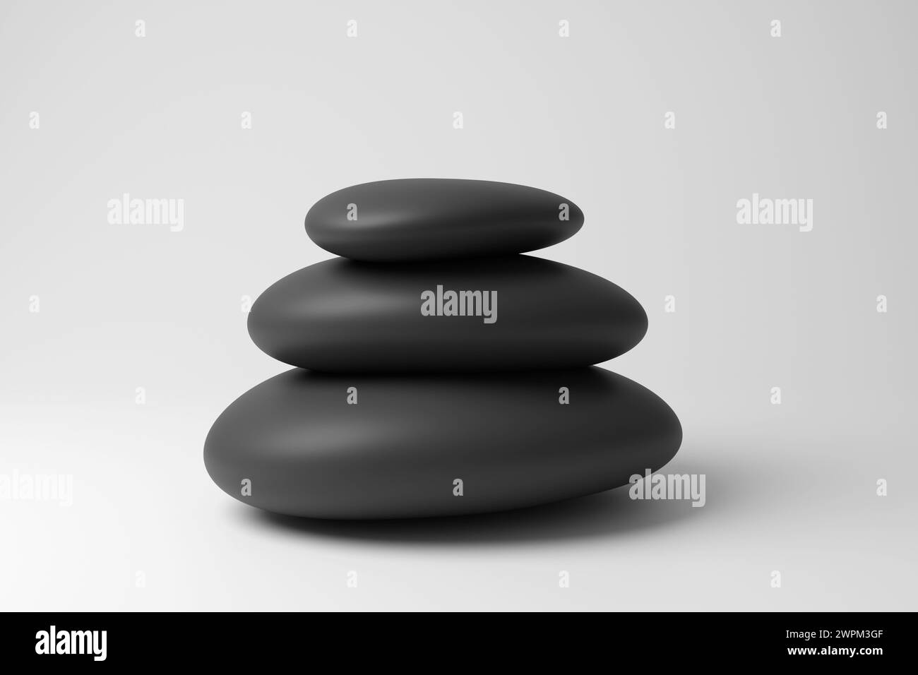 Piccola pila di ciottoli neri arrotondati che formano un cairn su sfondo bianco in bianco e monocromatico e minimalista. Concetto di memoriali, meditazione e relax Foto Stock