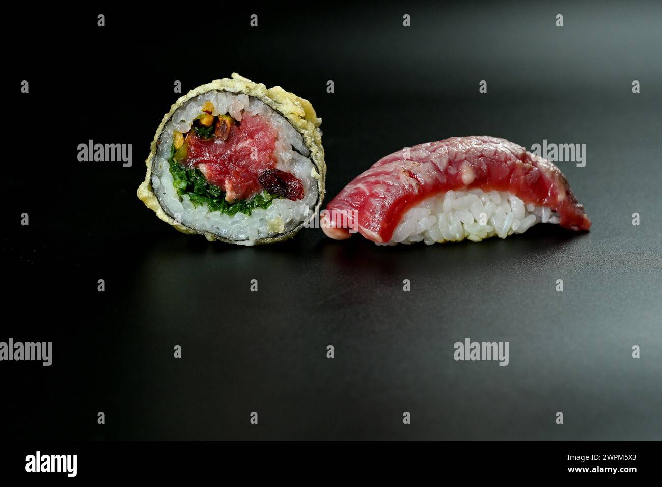 Un primo piano di sushi su una superficie scura di tavoletta Foto Stock