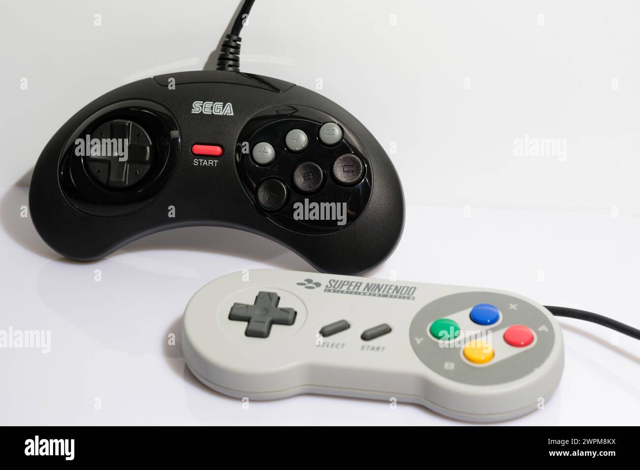 Newcastle Regno Unito: 21 gennaio 2024: Console a 16 bit guerre due controller di gioco retrò; sega Megadrive e Super Nintendo su sfondo bianco Foto Stock