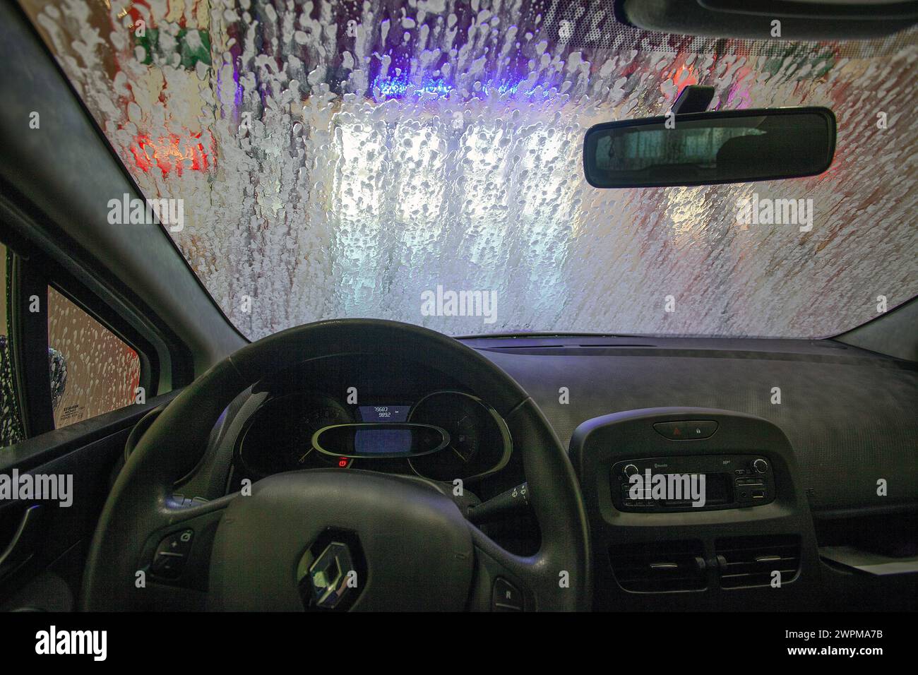 Auto in un autolavaggio. Vista dall'interno di una vettura che avanza attraverso un lavaggio automatico. Foto Stock