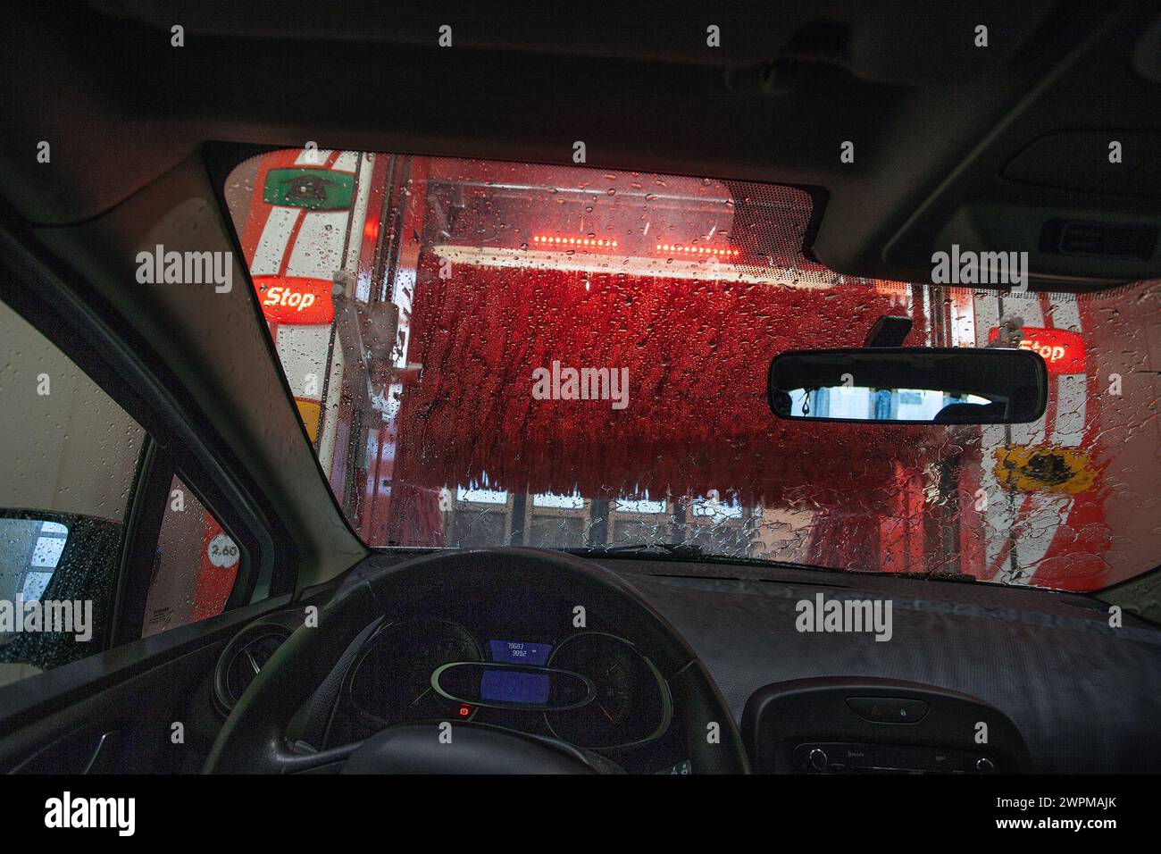 Auto in un autolavaggio. Vista dall'interno di una vettura che avanza attraverso un lavaggio automatico. Foto Stock