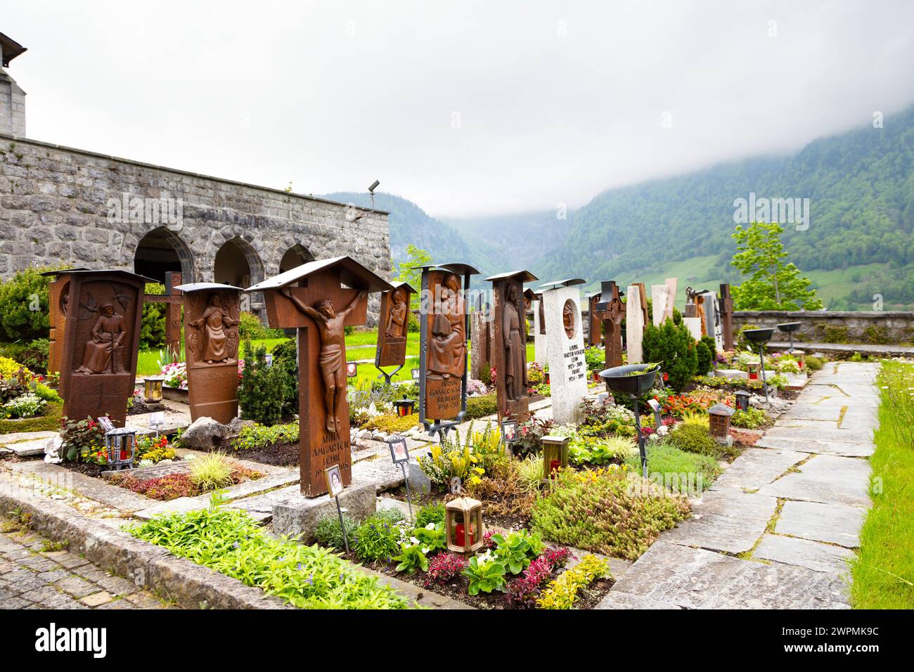 Tombe presso il sagrato terrazzato presso la Chiesa parrocchiale del Sacro cuore di Gesù, Lungern, Svizzera Foto Stock