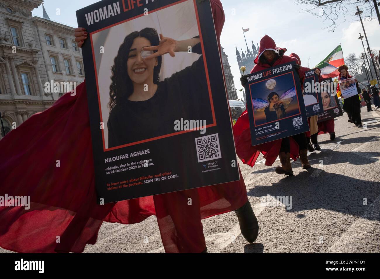 Londra, Regno Unito, 8 marzo 2024, le donne iraniane vestite con costumi da Handmaid tale camminano dalla piazza del Parlamento all'ambasciata iraniana a Kensington. Passando attraverso il centro di Londra, la processione si ferma in diversi luoghi di interesse famosi, tra cui Downing Street e Trafalgar Square. Il gruppo delle donne spera di richiamare l'attenzione sull'abuso dei diritti umani in Iran. Credito: James Willoughby Foto Stock