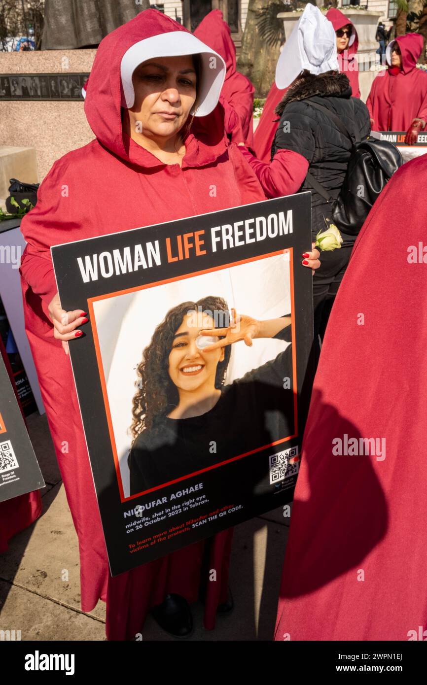 Londra, Regno Unito, 8 marzo 2024, le donne iraniane vestite con costumi da Handmaid tale camminano dalla piazza del Parlamento all'ambasciata iraniana a Kensington. Passando attraverso il centro di Londra, la processione si ferma in diversi luoghi di interesse famosi, tra cui Downing Street e Trafalgar Square. Il gruppo delle donne spera di richiamare l'attenzione sull'abuso dei diritti umani in Iran. Credito: James Willoughby Foto Stock