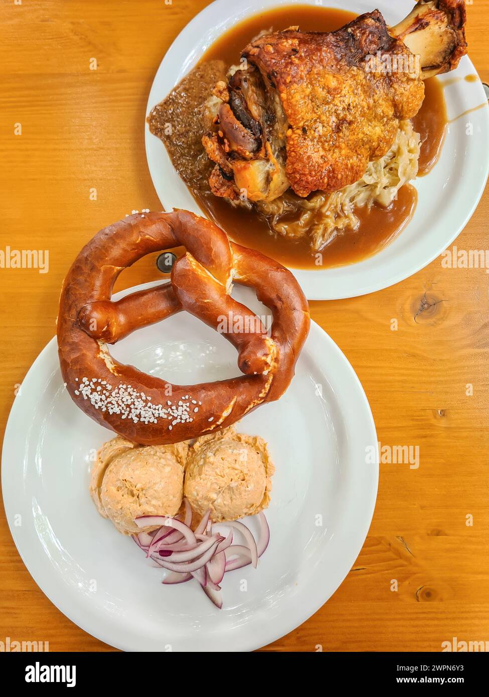 Pretzel e Obazda e nocciolo di maiale con cavolo servito come pasto bavarese Foto Stock