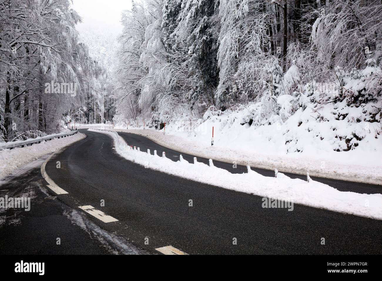 Inverno a Kesselbergstraße, curva con segnalatori luminosi sulla riserva centrale Foto Stock