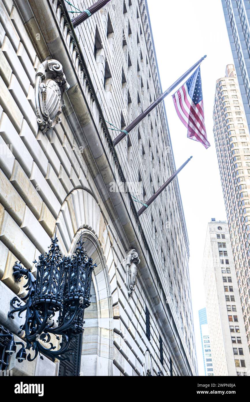 Vista ad angolo basso dell'esterno dell'edificio della Federal Reserve Bank of New York e della bandiera americana, New York City, New York, USA Foto Stock