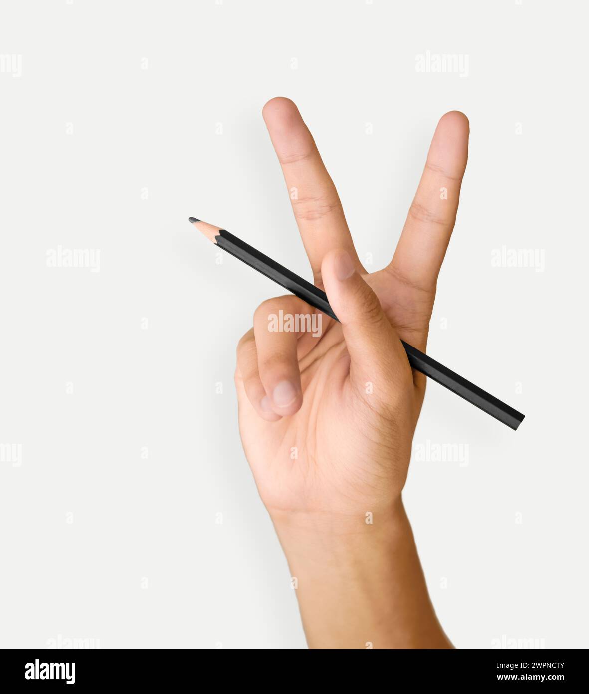 La mano di un uomo tiene una matita nera su sfondo bianco, tagliata e isolata Foto Stock