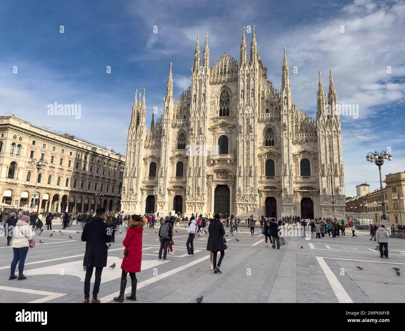 La gente cammina in Piazza del Duomo di fronte al Duomo di Milano, la cattedrale cattolica della città in Italia. Foto Stock