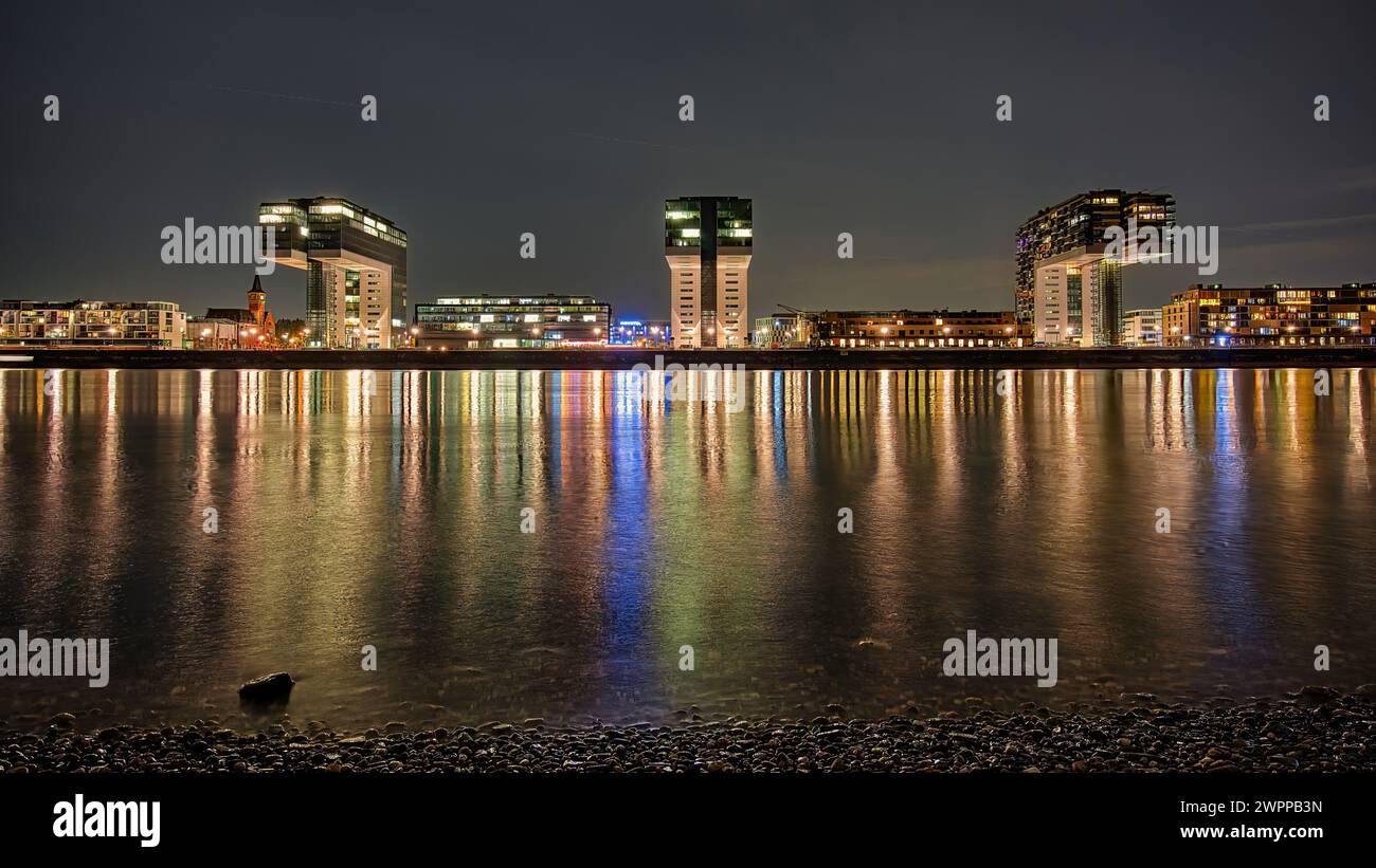 Paesaggio urbano illuminato di Colonia, Germania, vicino all'acqua di notte Foto Stock