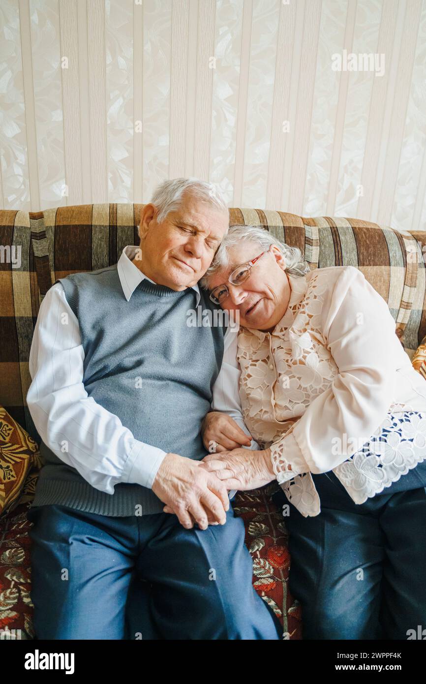 Anziana coppia d'amore romantica anziana. Vecchio pensionato donna insieme. Moglie anziana in un comodo maglione casalingo.anziano che abbraccia baciano la gente pensionato.Hap Foto Stock