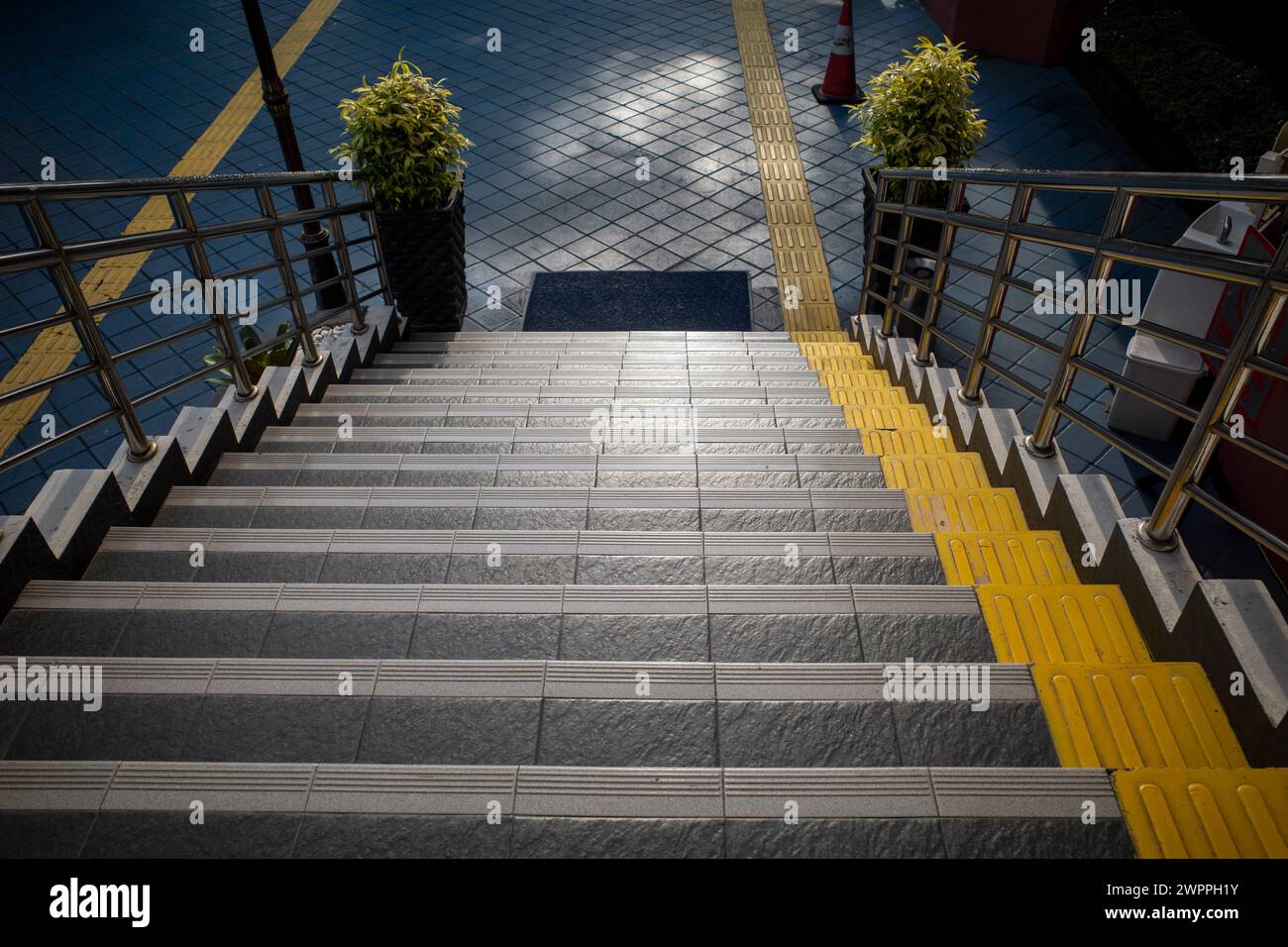 Scala con pavimentazione tattile gialla, passerella testurizzata per non vedenti. Foto Stock
