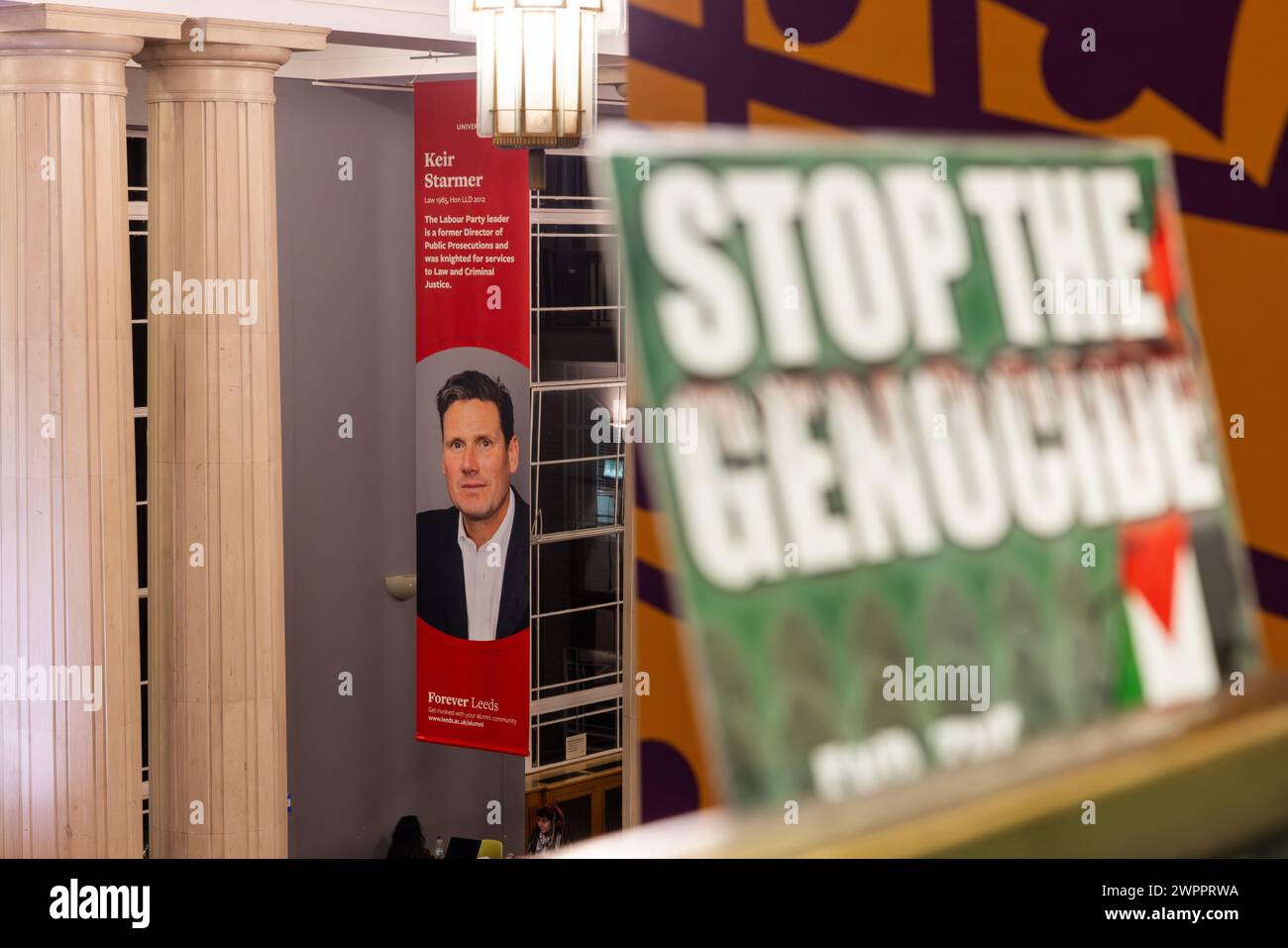 Leeds, Regno Unito. 08 MAR, 2024. Ferma che il manifesto del genocidio sia sfocato nel bosco, mentre il grande poster di Kier Starmer è appeso sullo sfondo. Preso all'occupazione studentesca dell'edificio Parkinson dell'UOL. Credito Milo Chandler/Alamy Live News. Credito Milo Chandler/Alamy Live News Foto Stock