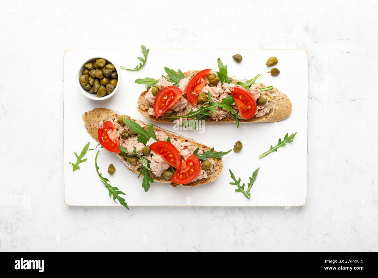 Brindisi al tonno con rucola, pomodori e pane intero di segale, vista dall'alto Foto Stock