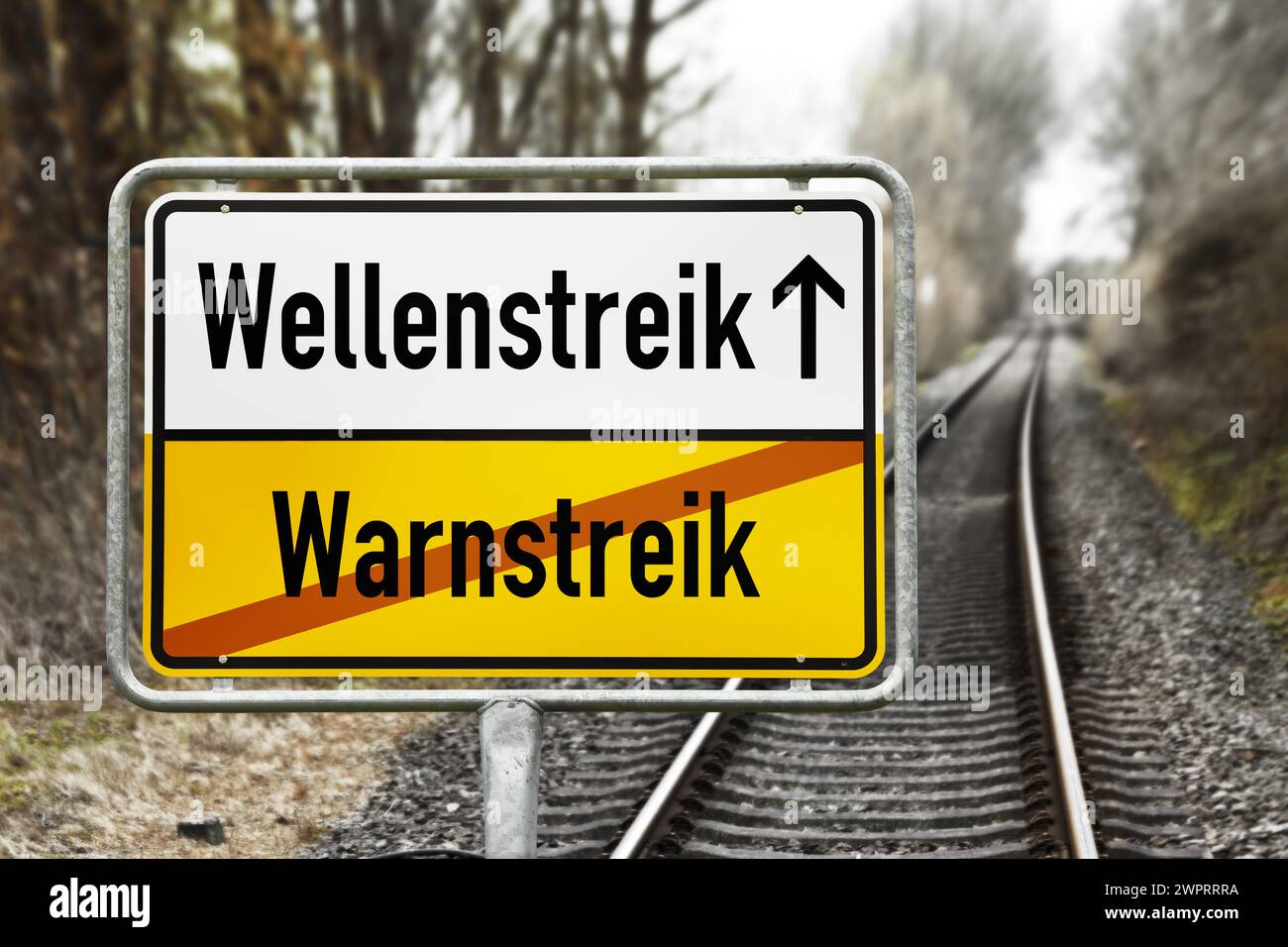 Cartello con le parole 'Wellenstreik' e le parole barrate 'Warnstreik' davanti a Empty Rails, fotomontaggio Foto Stock
