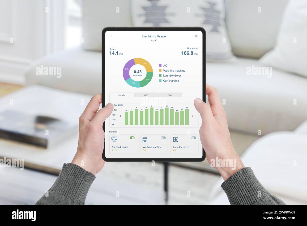 Tablet portatile con app che monitora il consumo di elettricità in casa. Concetto di gestione dell'energia, tecnologia e soluzioni abitative intelligenti Foto Stock