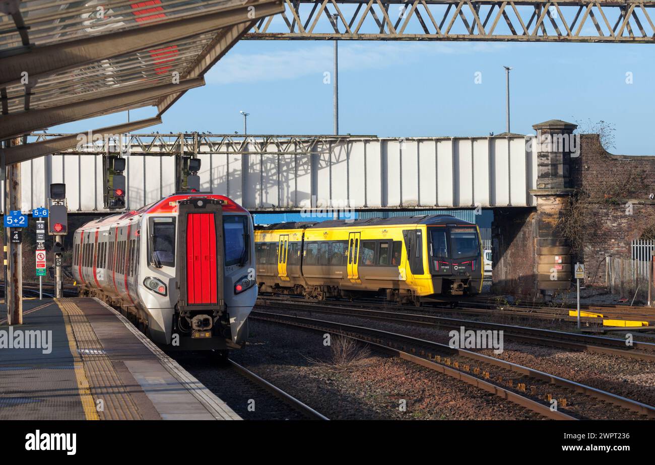 Merseyrail Stadler classe 777 3rd treno elettrico 777003 a Chester passando un Transport for Wales CAF classe 197 197014 Foto Stock