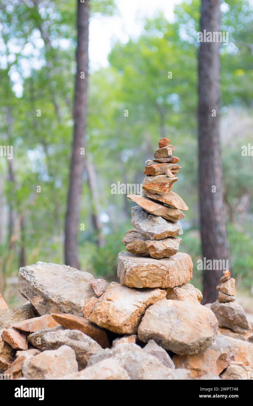 Impilate con cura, pietre leggermente rosse formano una figura di pietra, cairn, waymark, marcatore, pineta sparsa, sentiero escursionistico da Sant Elm al vecchio Foto Stock