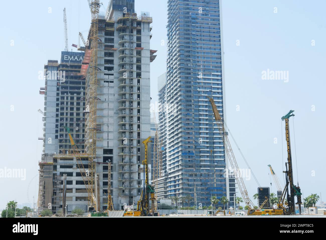 Gru torreggianti e grattacieli in costruzione contro un cielo limpido rappresentano il continuo sviluppo urbano di Dubai. Dubai, Emirati Arabi Uniti - 15 agosto 2023 Foto Stock
