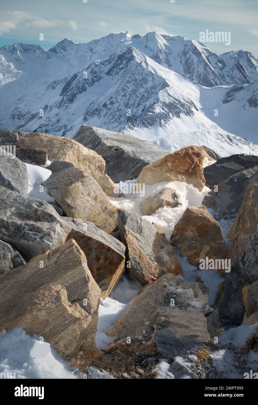 Paesaggio alpino con rocce gialle sul fronte e vette coperte da neve e nuvole, splendidi colori sulla cima di un ghiacciaio, Hintertux, Austria Foto Stock