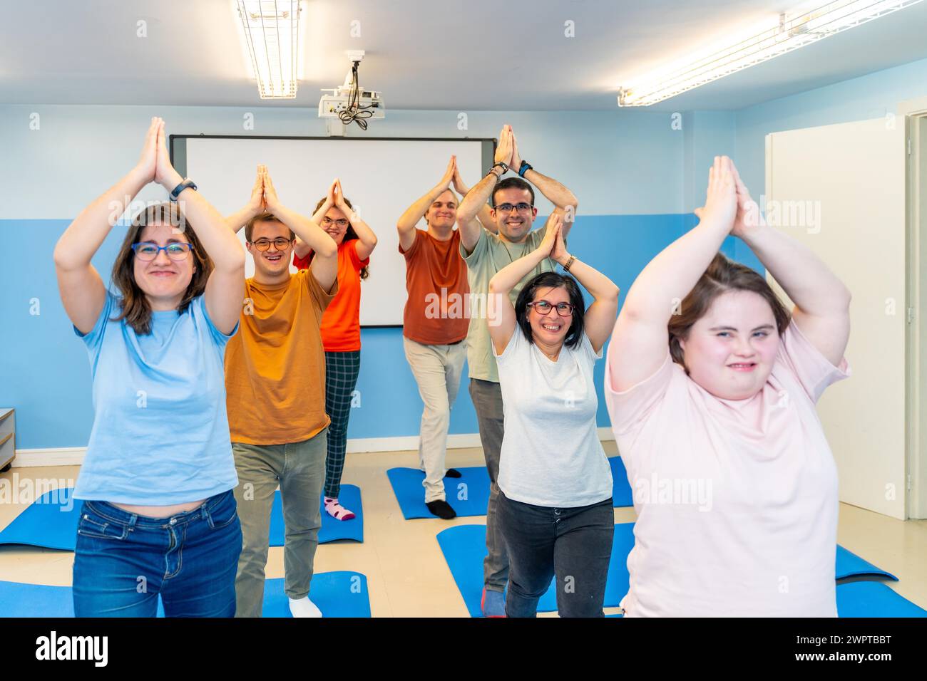 Gruppo di persone disabili che praticano yoga insieme in una palestra con buone vibrazioni Foto Stock