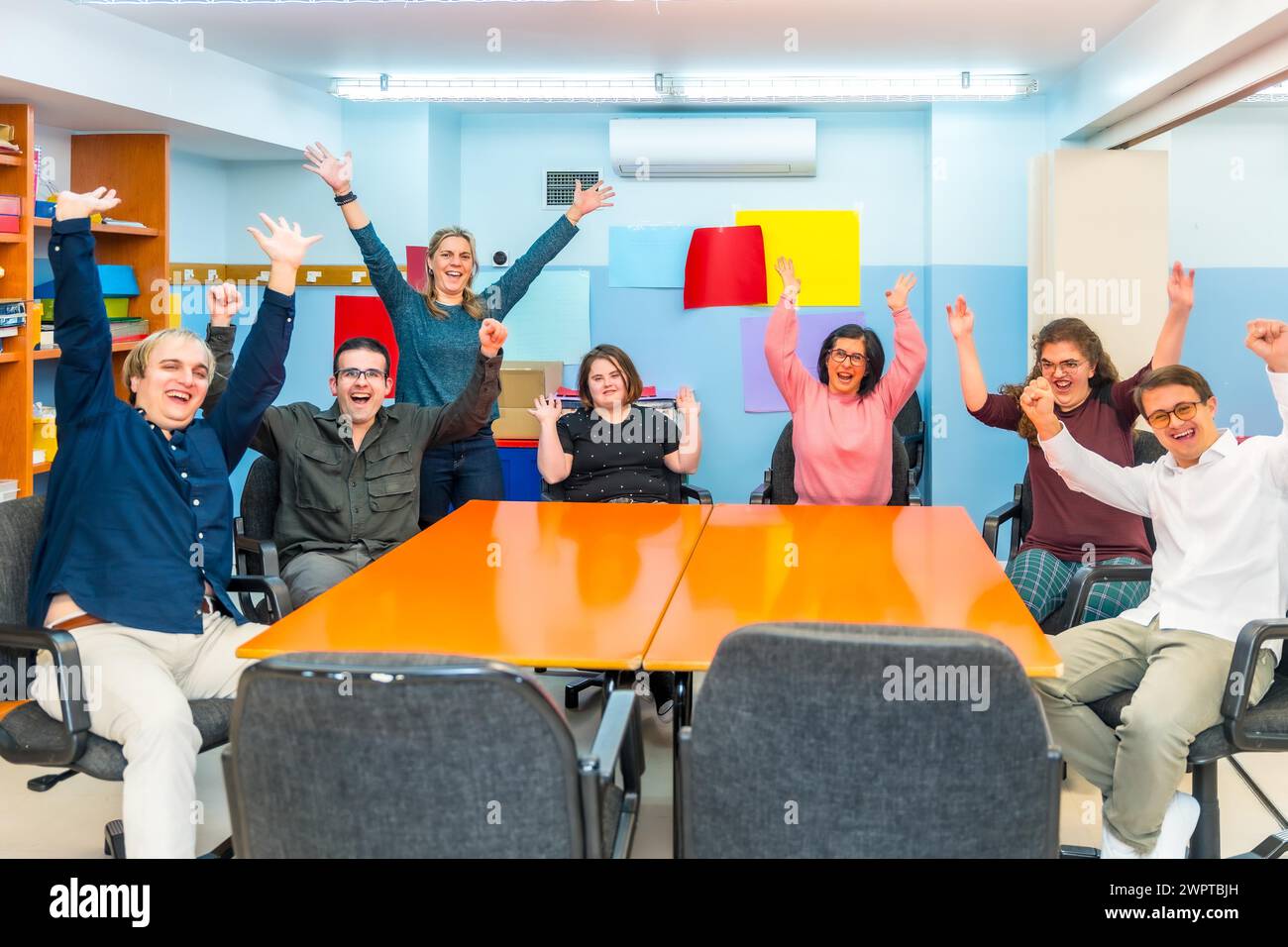 Ritratto di persone felici e gioiose con esigenze speciali in una classe con insegnante Foto Stock