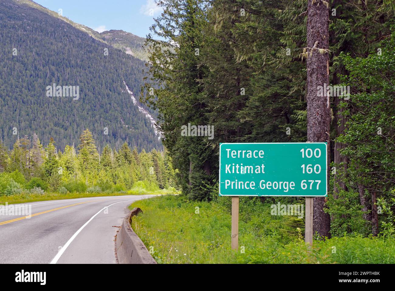 Cartello stradale con distanze sulla Yellowhead Highway, nessun traffico, natura selvaggia, Terrace, Kitimat, principe George, Columbia Britannica, Canada Foto Stock