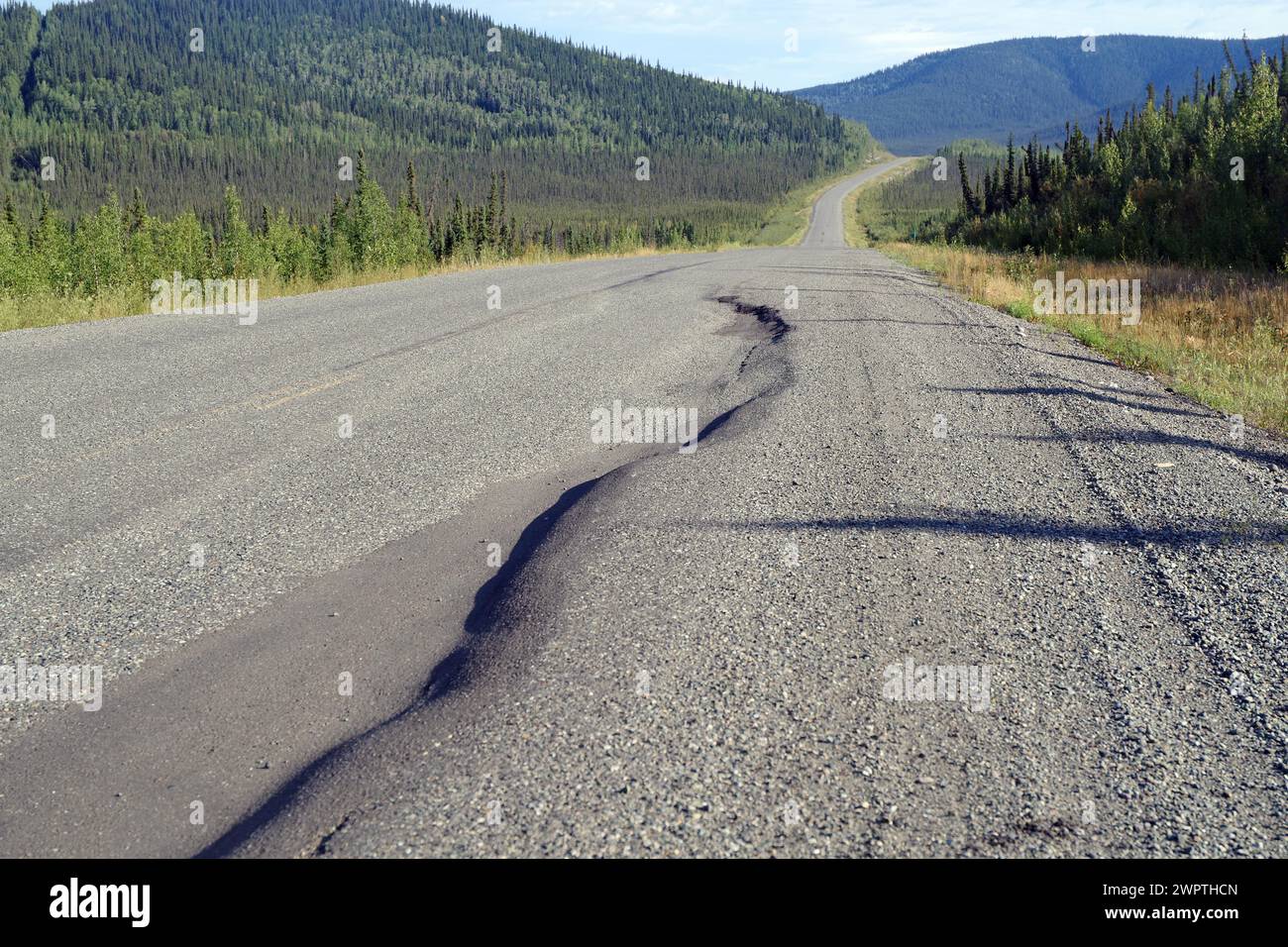 Strada con grandi dossi e buche, natura selvaggia e vastità, Alaska Highway, territorio dello Yukon, Canada Foto Stock