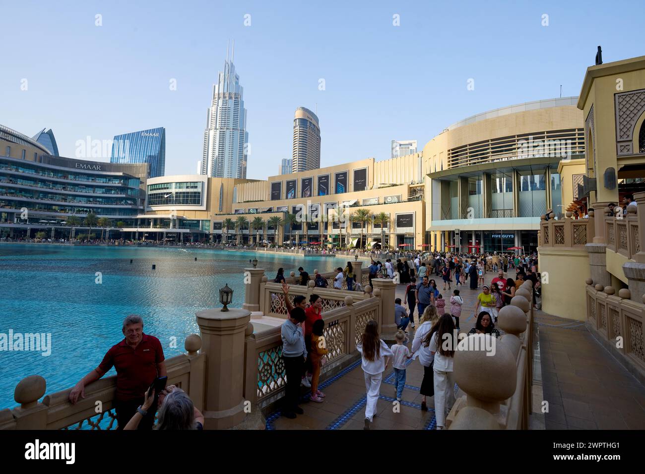 Turisti di fronte al grattacielo sullo sfondo del lago Burj Khalifa. Dubai, Emirati Arabi Uniti Foto Stock