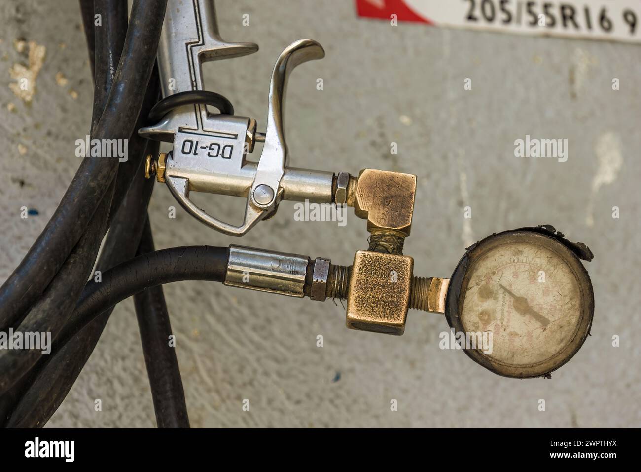 Fotografia ravvicinata di un manometro rotto e di un mandrino pneumatico attaccato a un tubo, in un'officina di auto nella città di Arcabuco, nella Colombia centrale. Foto Stock