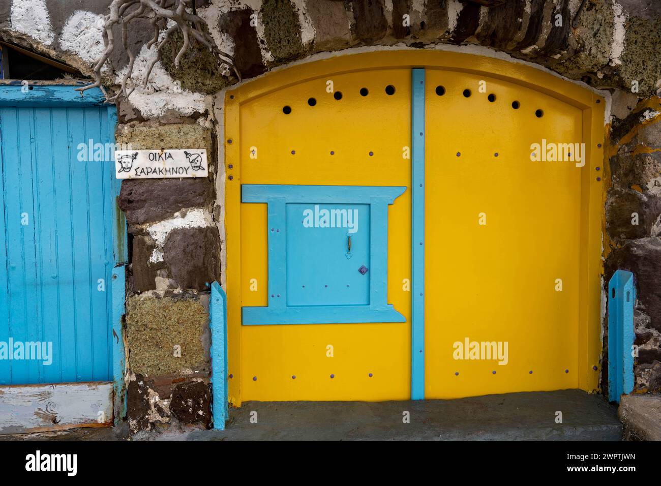Porta gialla del garage in pietra, clima, Milos, Cicladi, Grecia Foto Stock