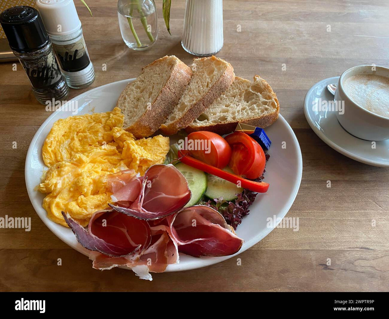 Cibo, colazione, uova strapazzate, pane, prosciutto altoatesino, pomodori, cetrioli, cappuccino, sale, pepe, Stoccarda, Baden-Wuerttemberg, Germania Foto Stock