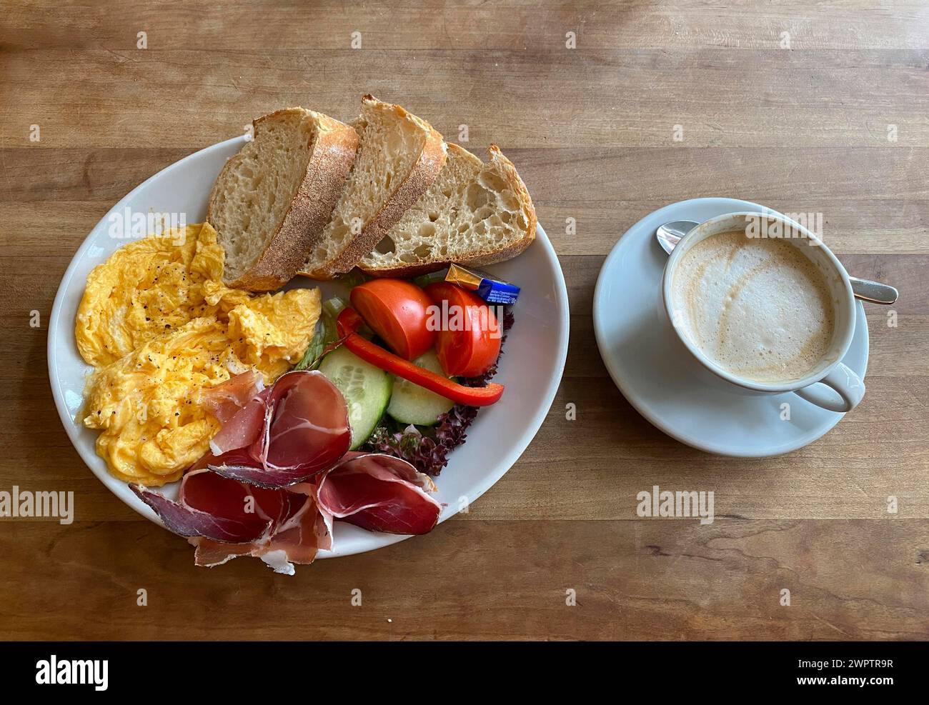 Cibo, colazione, uova strapazzate, pane, prosciutto altoatesino, pomodori, cetriolini, cappuccino, Stoccarda, Baden-Wuerttemberg, Germania Foto Stock