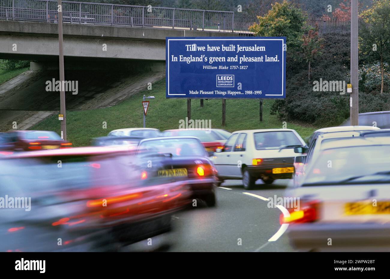 Una citazione di William Blake riprodotta su un cartellone che promuove la Leeds Development Corporation accanto a una strada congestionata. Doveva essere ironico?! Foto Stock
