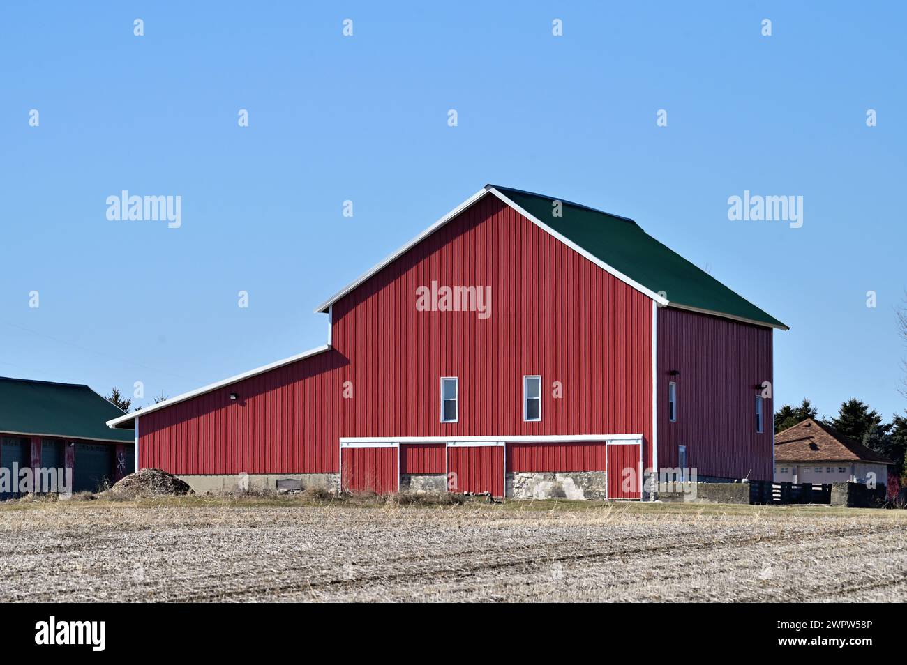 Lee, Illinois, Stati Uniti. Un fienile rosso brillante che crogiola il sole mattutino nell'Illinois rurale e agricolo. Foto Stock