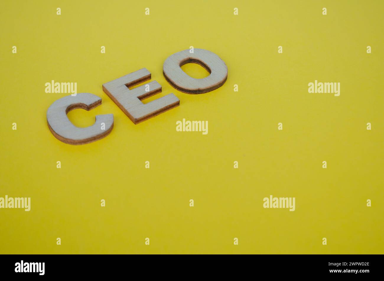 Lettere in legno del CEO su sfondo giallo della copertina. Concetto di livello Senior Executive. Foto Stock