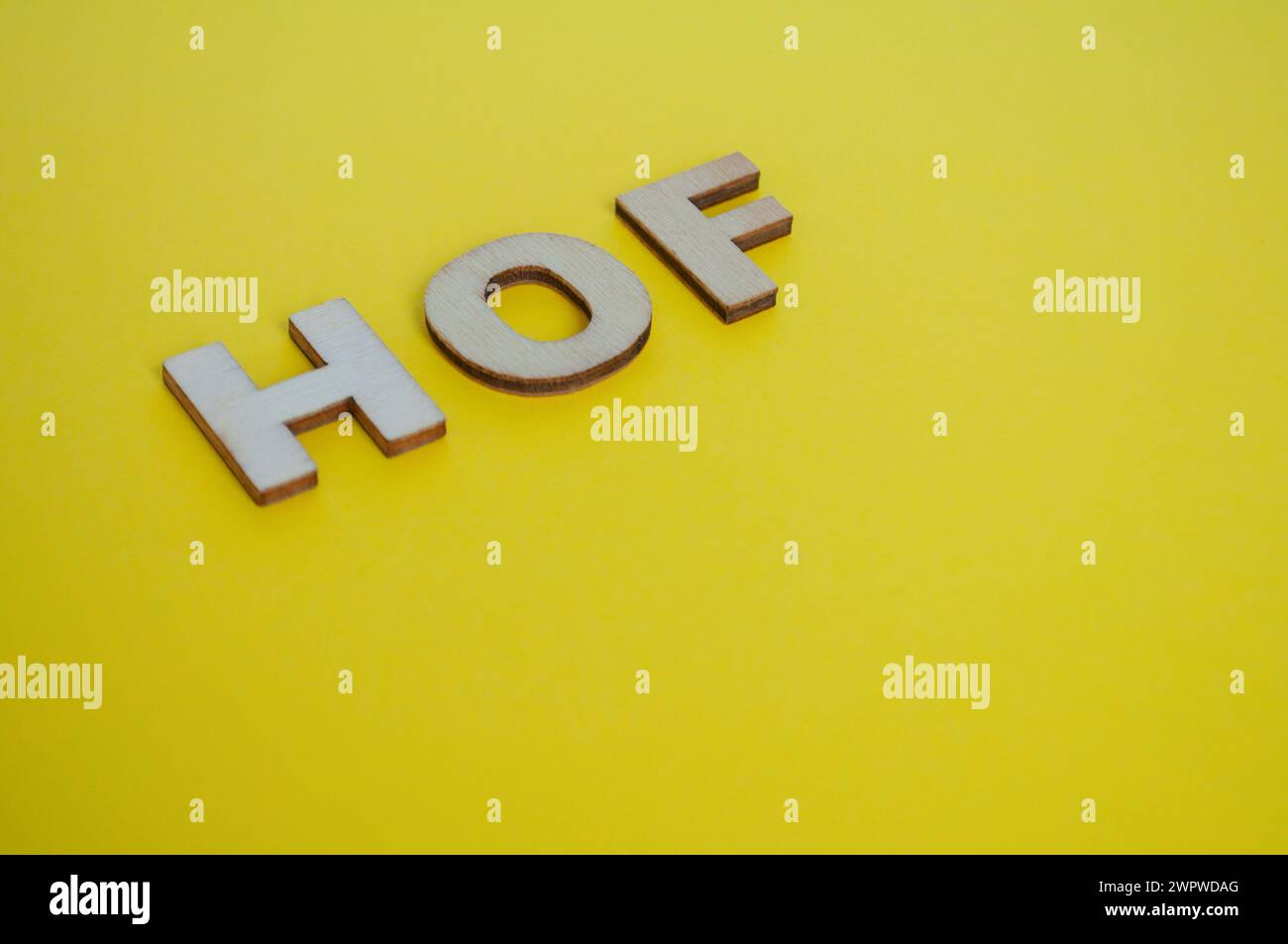 HOF lettere in legno su sfondo giallo. Concetto di livello Senior Executive. Foto Stock