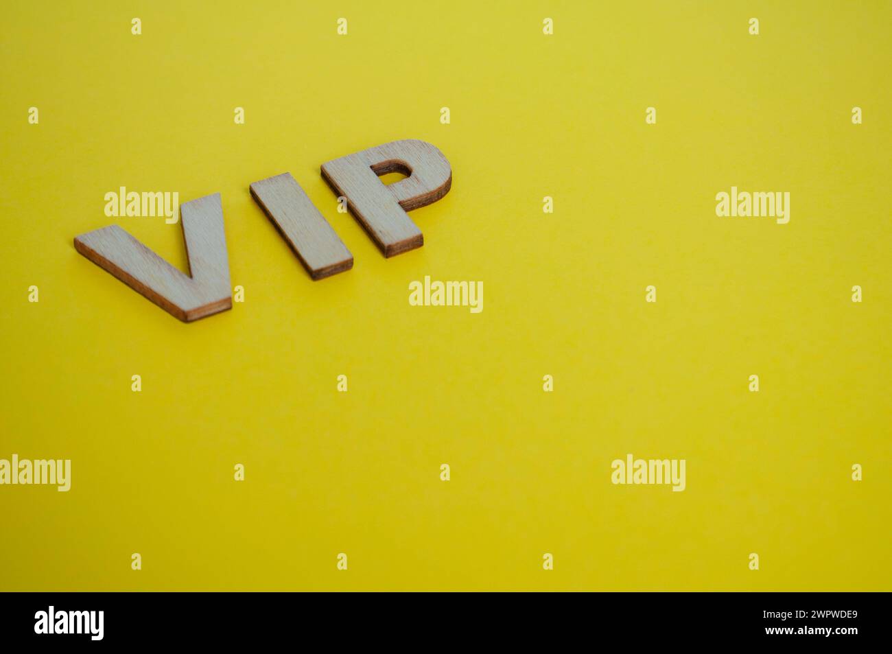 Lettere VIP in legno che rappresentano persone molto importanti su sfondo giallo. Foto Stock