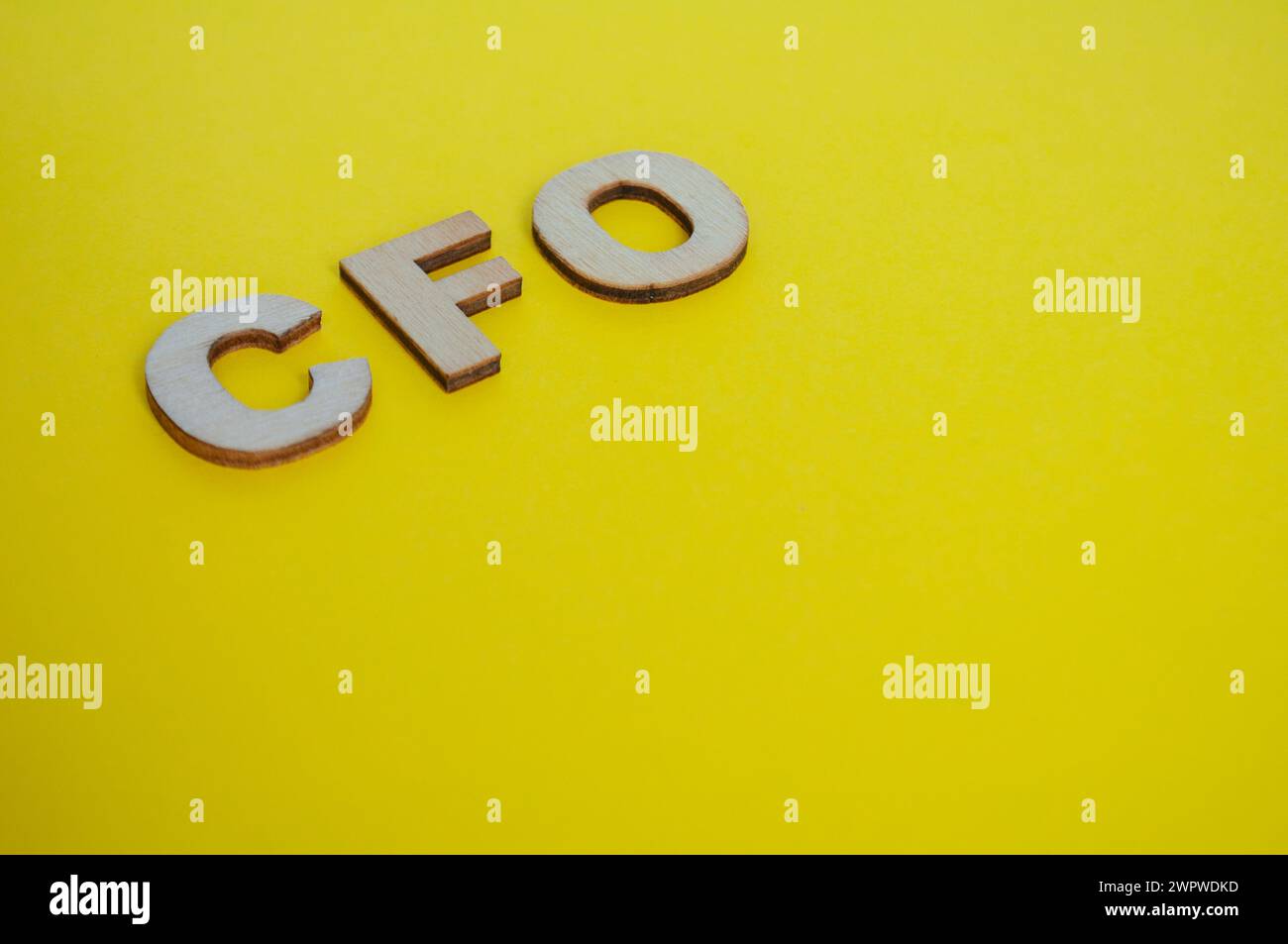 Lettere in legno CFO su sfondo giallo della copertina. Concetto di livello Senior Executive. Foto Stock