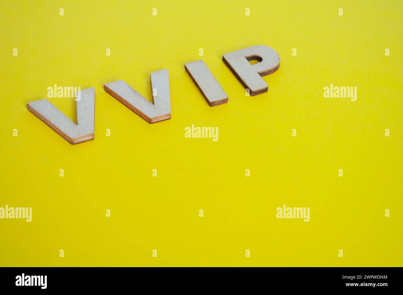 Lettere VIP in legno che rappresentano persone molto importanti su sfondo giallo. Foto Stock