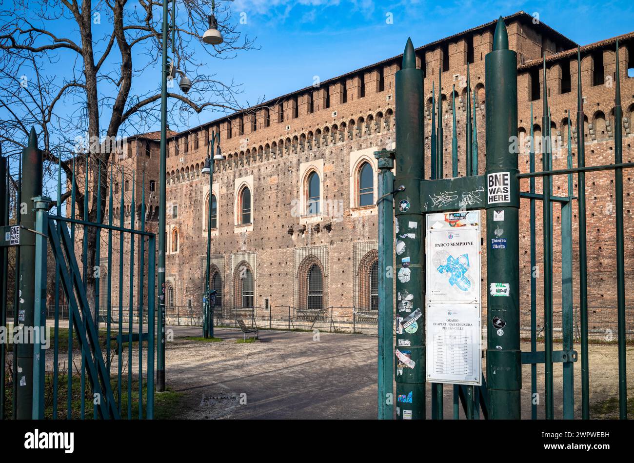 Un ingresso al Parco Sempione e alle mura esterne del Castello Sforzesco, o Castello di Milano, a Milano, Lombardia, Italia. Foto Stock